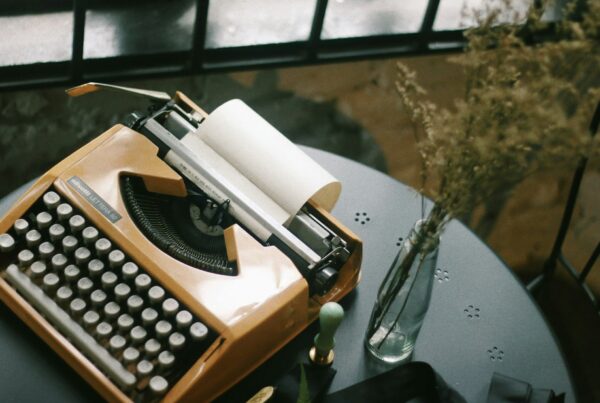 old school typewriter on a simple table with floral arrangement